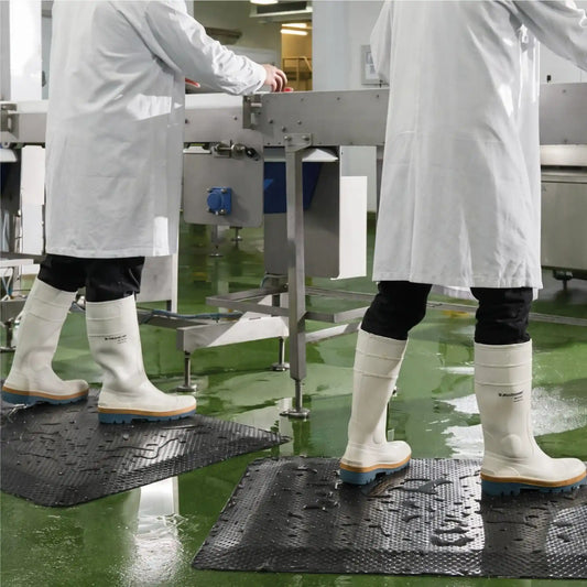 Tapis anti-fatigue professionnel pour atelier installé dans un environnement agroalimentaire humide pour réduire la fatigue des opérateurs.
