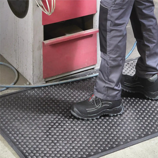 Tapis industriel grattant drainant de sécurité avec surface antidérapante pour les zones de production et ateliers industriels.