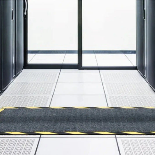 Tapis passe-câbles utilisé dans un centre de données pour protéger les câbles au sol et sécuriser les zones de circulation du personnel technique.