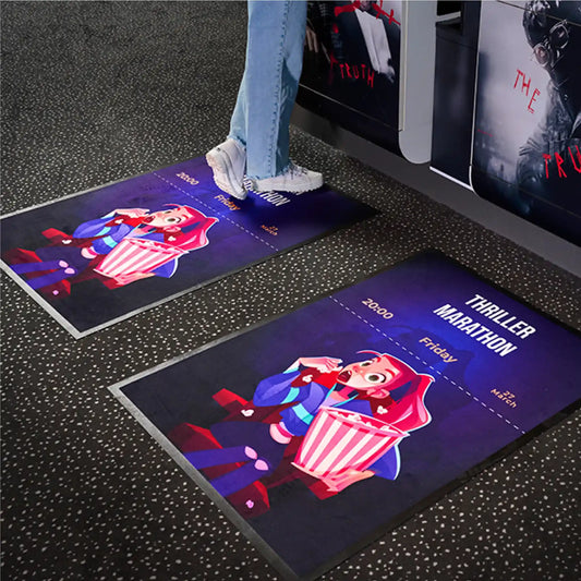 Tapis publicitaire personnalisé utilisé dans un cinéma pour promouvoir un événement ou une campagne marketing.