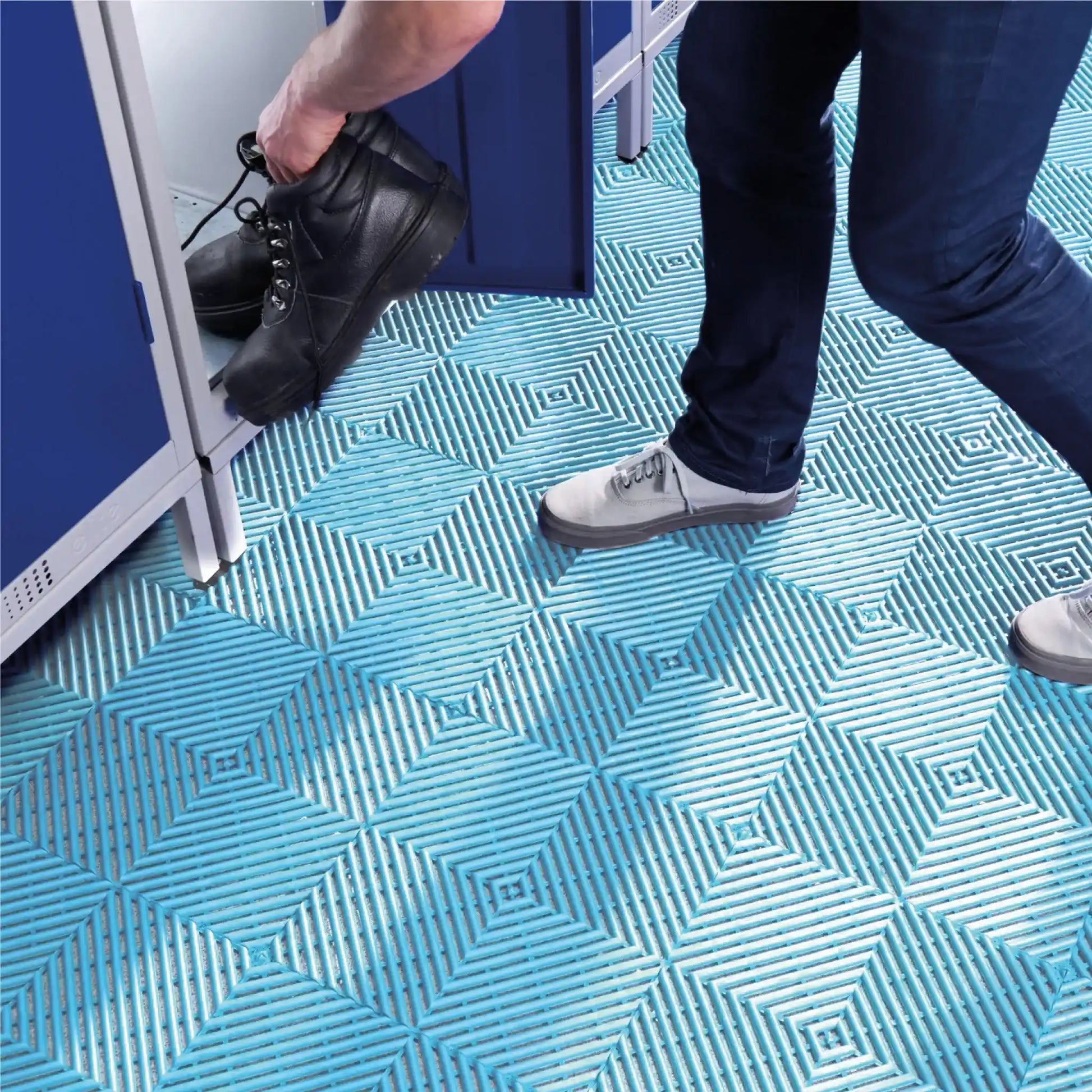 Utilisateur marchant sur des dalles drainantes PVC antidérapantes dans une zone humide de vestiaire ou d’espace collectif.