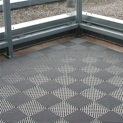 Revêtement de sol composé de dalles drainantes antidérapantes pour évacuer l’eau dans les espaces humides intérieurs et extérieurs.