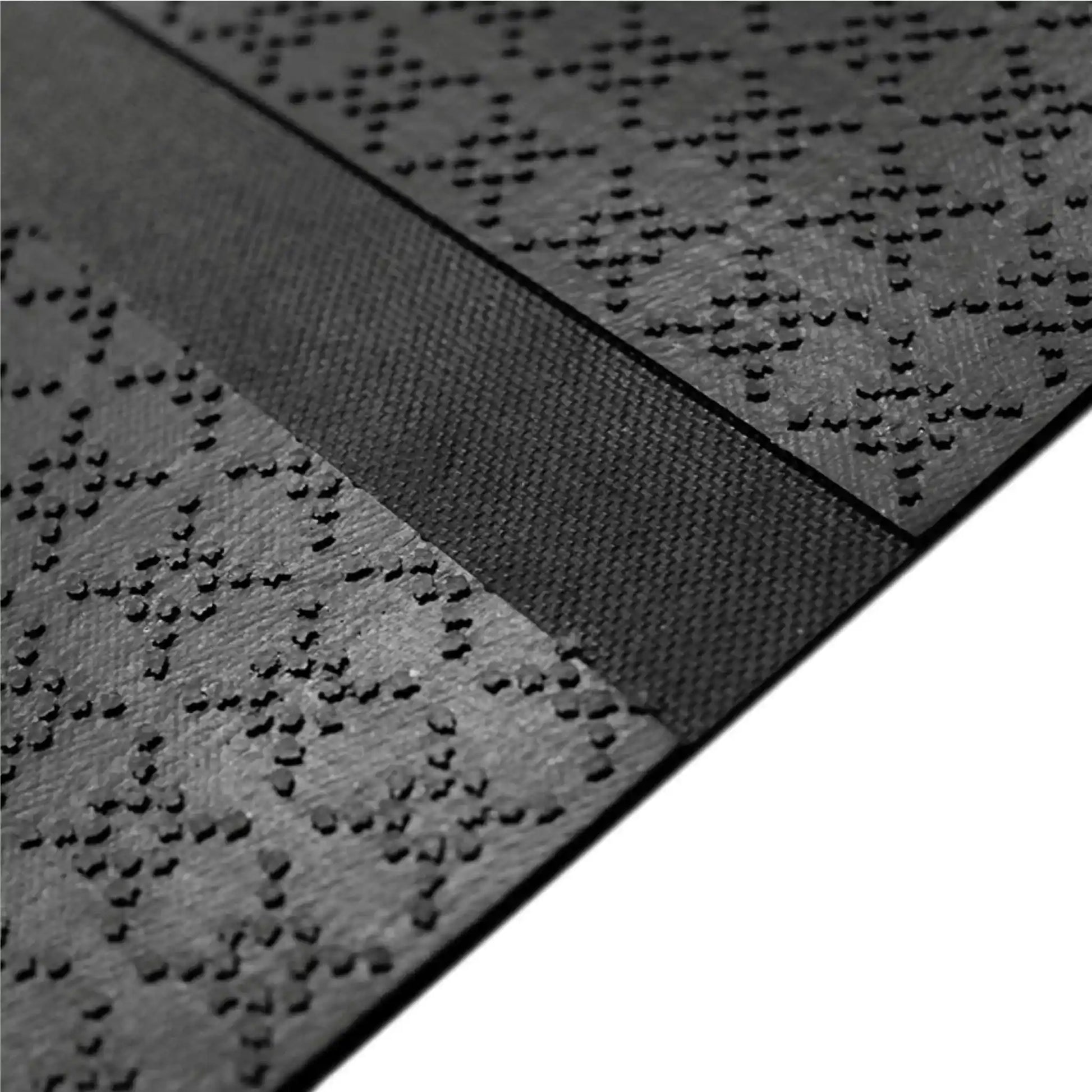 Vue détaillée de la face inférieure antidérapante du tapis de protection de câble assurant une excellente stabilité au sol.
