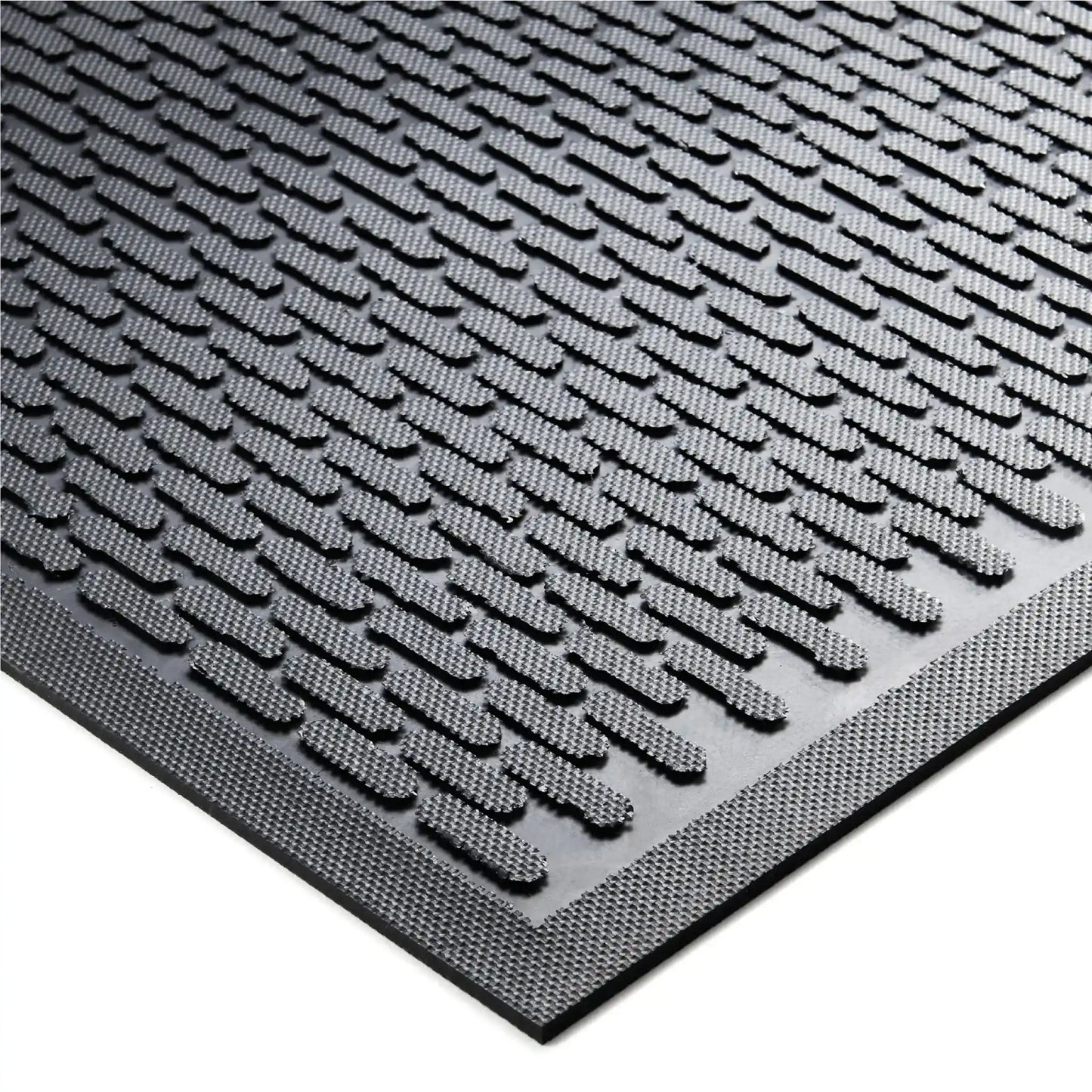 Gros plan sur la surface texturée d’un tapis d’entrée professionnel en caoutchouc offrant un fort pouvoir grattant.