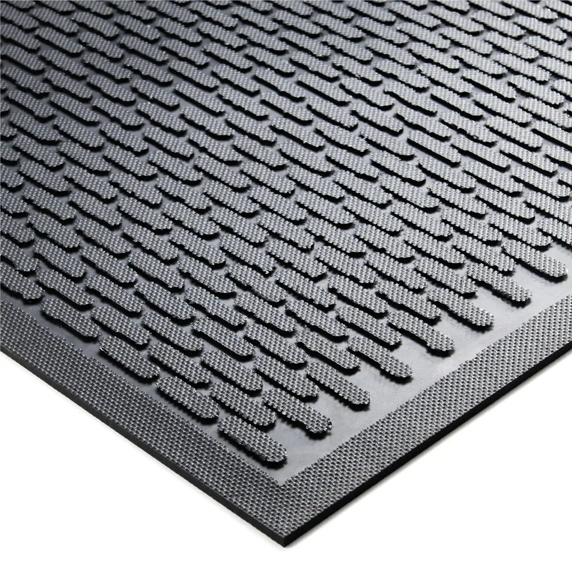 Gros plan sur la surface texturée d’un tapis d’entrée professionnel en caoutchouc offrant un fort pouvoir grattant.