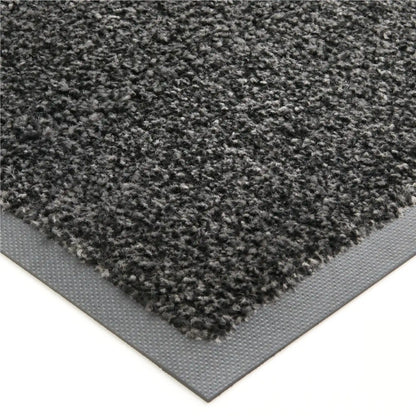 Gros plan sur la texture absorbante et la bordure antidérapante d’un tapis d’entrée professionnel écologique.