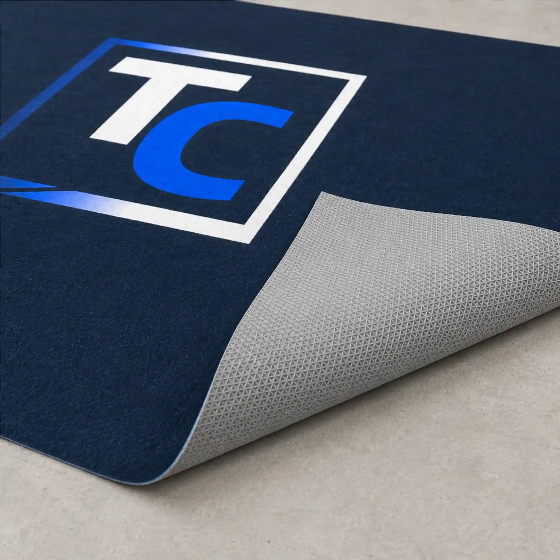 Revers antidérapant d’un tapis promotionnel personnalisé sans bordure assurant une excellente stabilité sur les sols intérieurs.