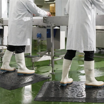 Tapis anti-fatigue professionnel pour atelier installé dans un environnement agroalimentaire humide pour réduire la fatigue des opérateurs.