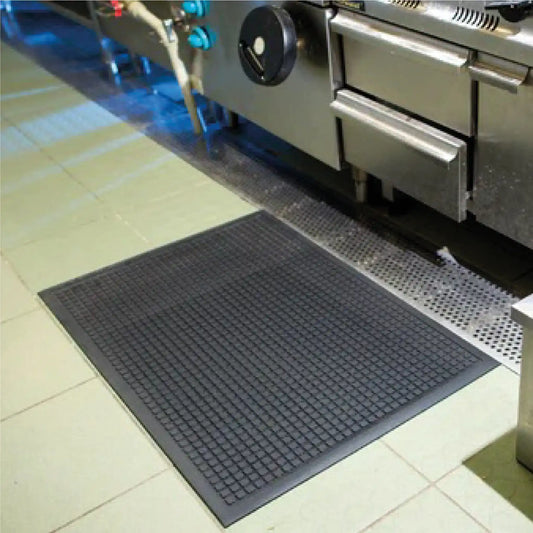 Tapis anti-fatigue professionnel industriel installé dans une cuisine professionnelle pour réduire la fatigue lors des longues stations debout.