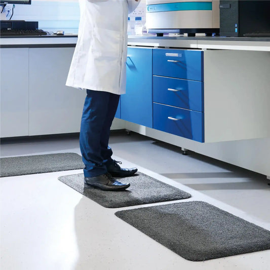 Tapis anti-fatigue professionnel intérieur utilisé dans un laboratoire pour améliorer le confort lors des stations debout prolongées.