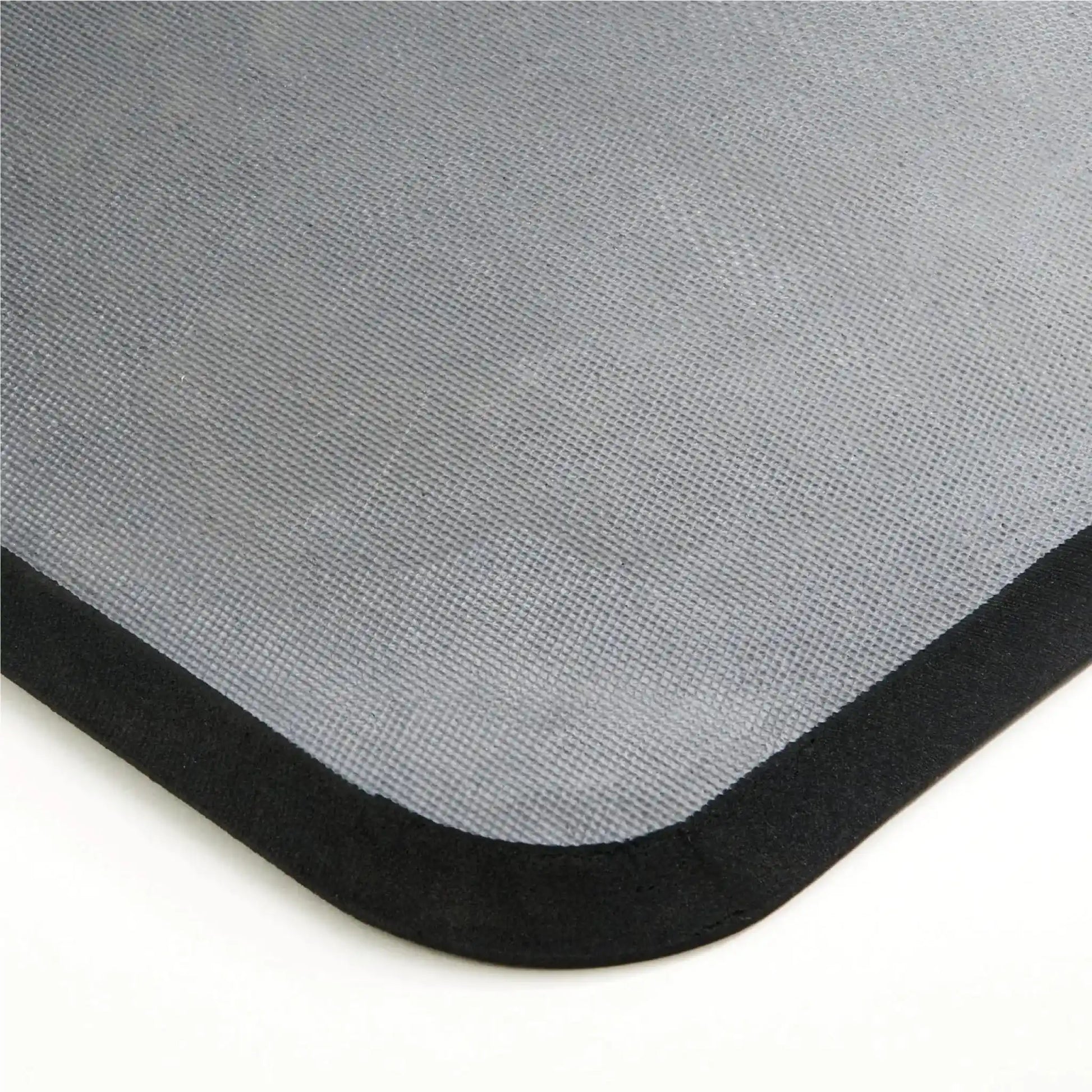 Détail de l’épaisseur et de la finition d’un tapis anti-fatigue professionnel en mousse avec bords biseautés de sécurité.
