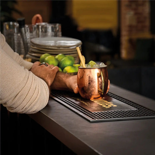 Tapis de bar personnalisé premium installé sur un comptoir de bar, offrant une surface antidérapante et un support publicitaire efficace.