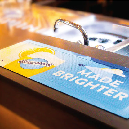 Tapis de bar personnalisé standard utilisé comme support publicitaire pour une marque de cocktail, offrant visibilité et protection du comptoir.