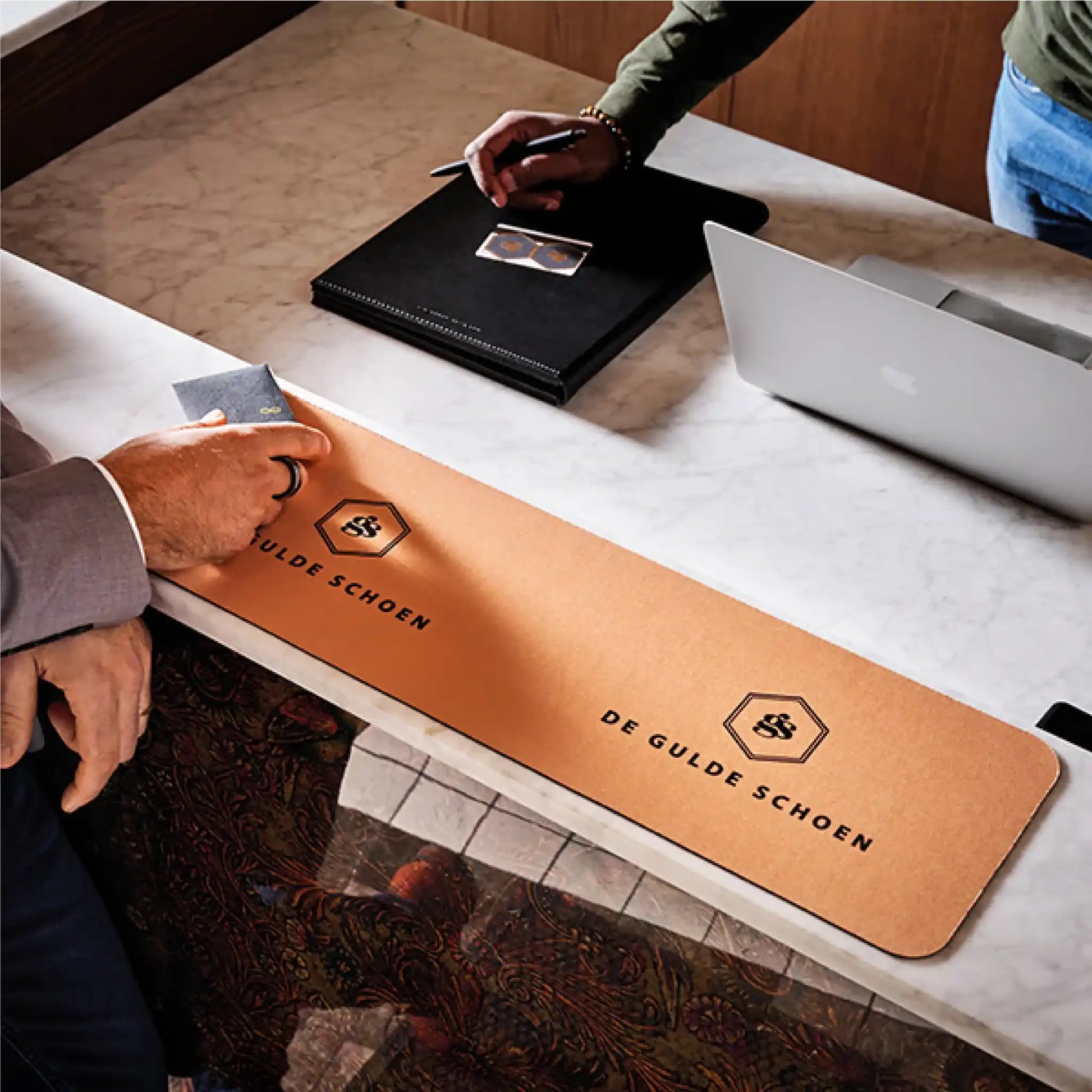 Tapis de comptoir personnalisé classique utilisé sur un comptoir de magasin pour présenter une marque et protéger la surface d’accueil.