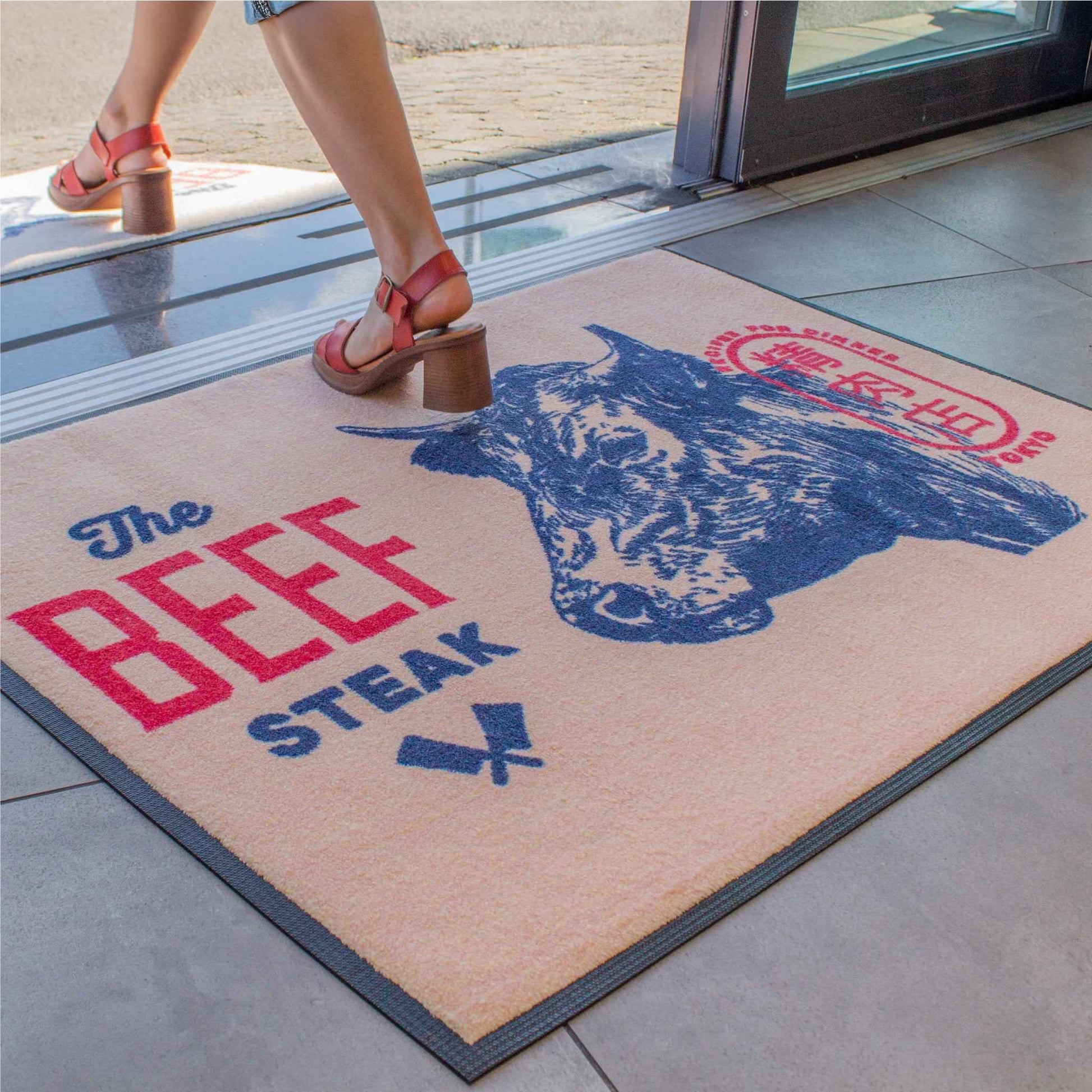 Tapis d'entrée premium personnalisé avec logo et visuel détaillé, conçu pour les zones à fort trafic dans les commerces et établissements professionnels.