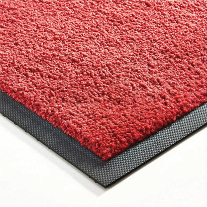 Détail de la surface et des finitions d’un tapis d’entrée professionnel couleur unie rouge.
