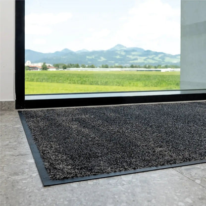 Tapis d’entrée professionnel écologique installé devant une baie vitrée pour retenir efficacement les salissures et l’humidité.