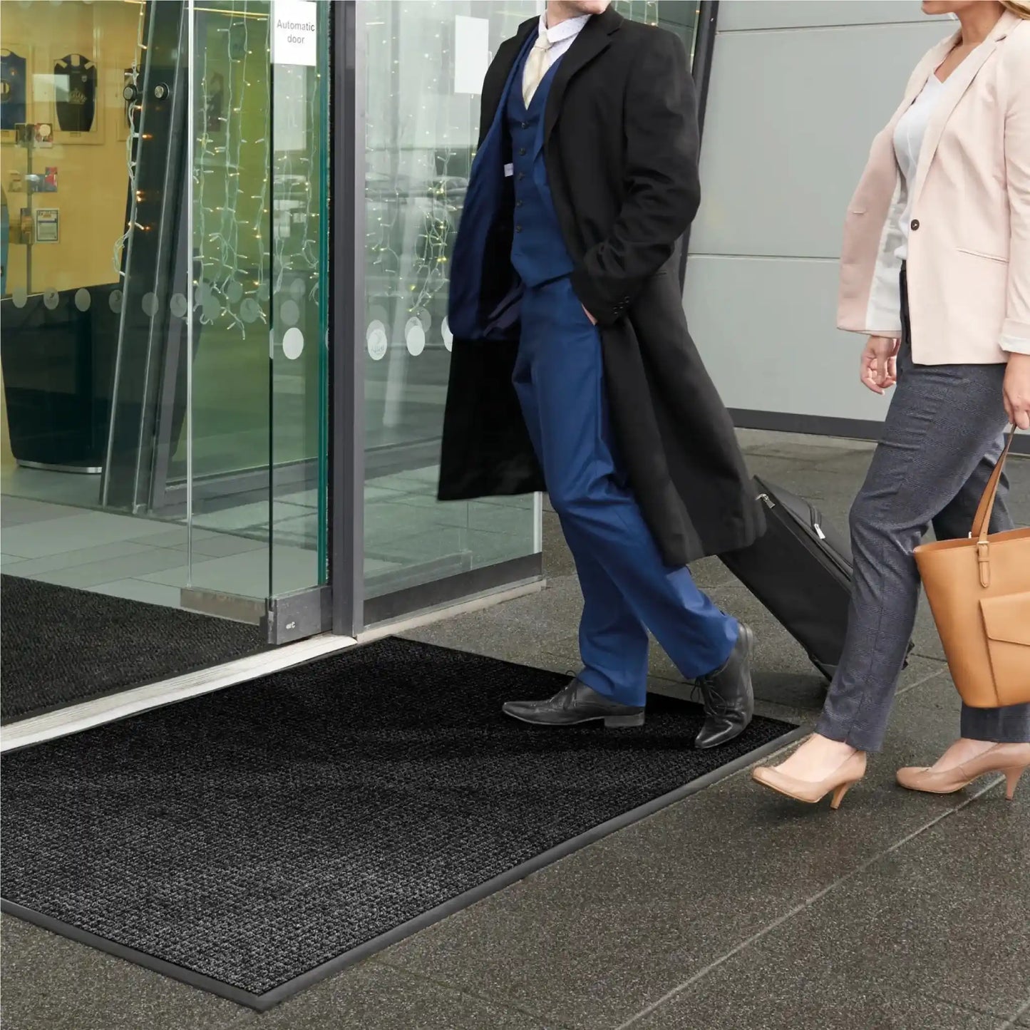 Tapis d’entrée professionnel à rétention d’eau placé devant une entrée vitrée pour limiter l’humidité et les salissures.