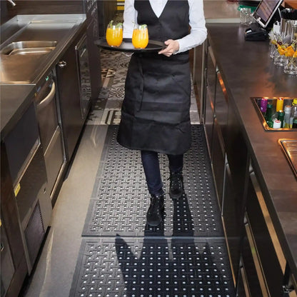 Tapis hygiénique drainant pour bar professionnel offrant une surface antidérapante confortable pour le personnel en mouvement derrière le comptoir.