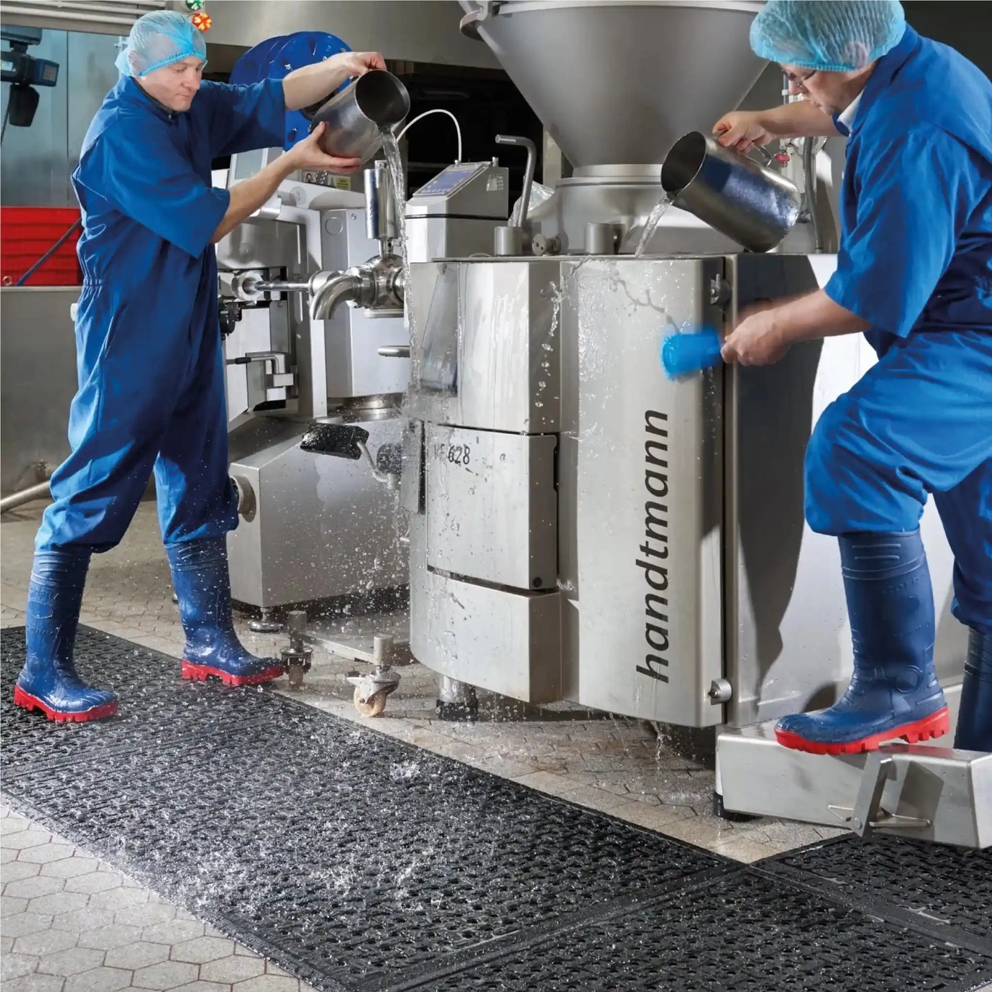 Tapis hygiénique drainant installé en industrie agroalimentaire pour sécuriser les zones humides et favoriser le drainage de l’eau lors des opérations de nettoyage.