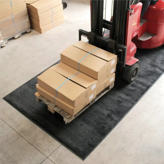 Tapis industriel chariot élévateur avec palette de marchandises dans un entrepôt logistique à fort trafic.