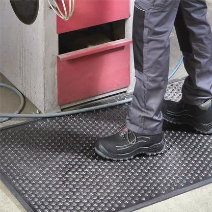 Tapis industriel grattant drainant de sécurité avec surface antidérapante pour les zones de production et ateliers industriels.