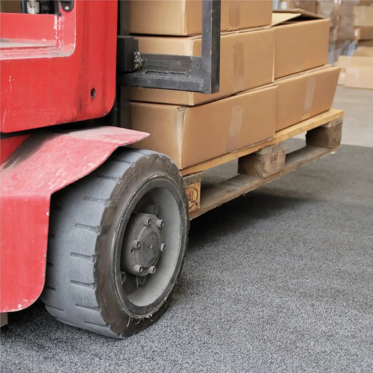 Tapis industriel pour chariot élévateur protégeant les sols d'entrepôt contre l'usure liée aux engins de manutention.