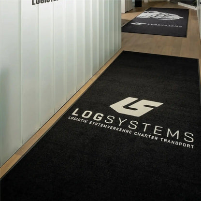 Tapis logo personnalisé grand format XXL installé dans un couloir d’entreprise pour guider les visiteurs tout en valorisant la marque.