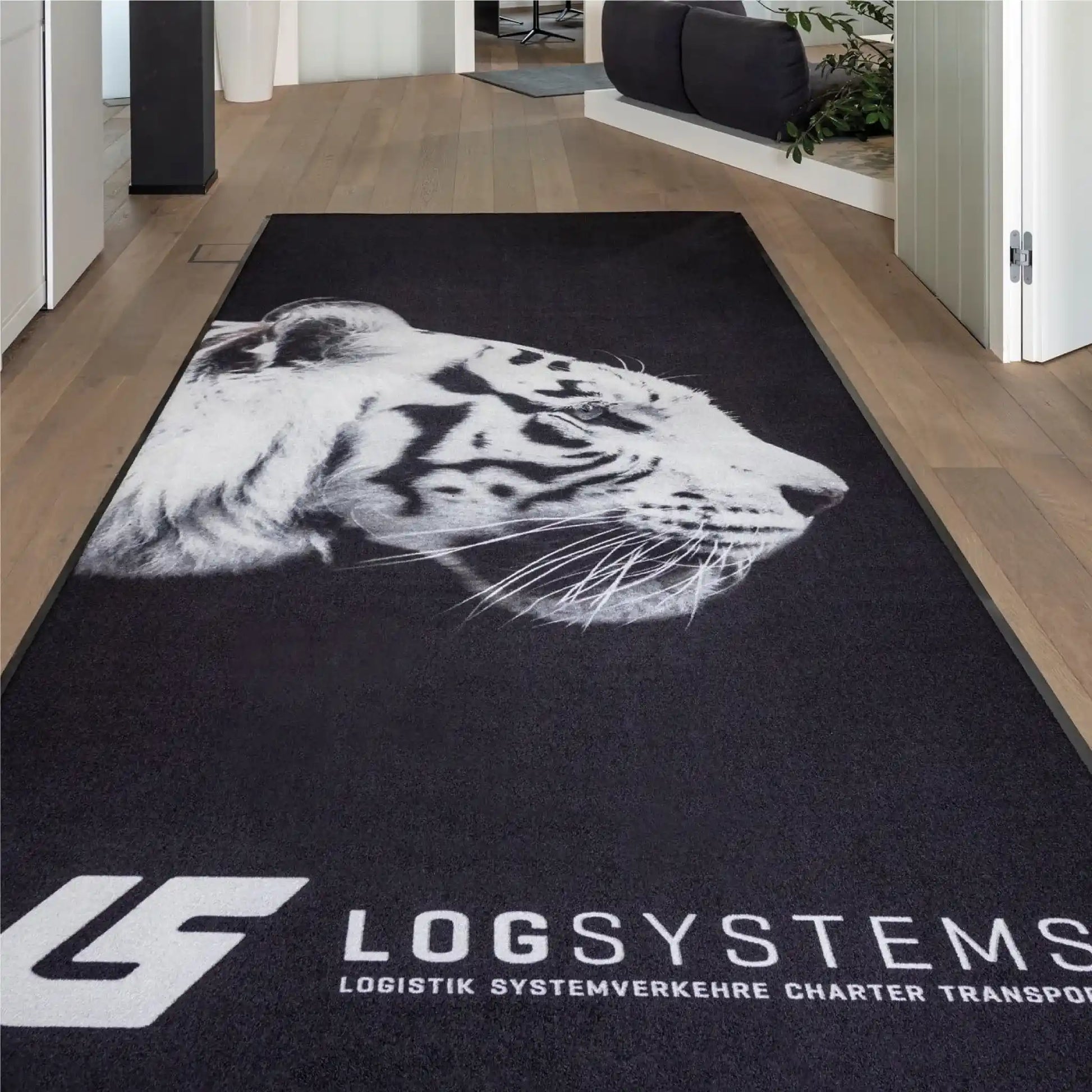 Tapis logo personnalisé grand format XXL installé dans les locaux d’une entreprise de logistique pour renforcer l’identité visuelle dès l’entrée.