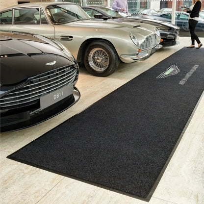 Tapis logo personnalisé grand format XXL utilisé dans un showroom automobile pour mettre en valeur l’image de marque et l’espace d’exposition.