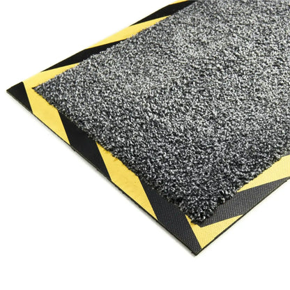 Gros plan sur un tapis passe-câbles avec bordure de sécurité jaune et noire assurant une excellente visibilité et une prévention efficace des chutes.