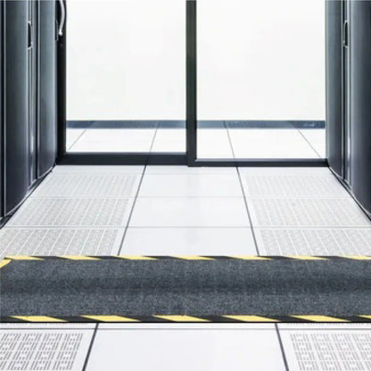 Tapis passe-câbles utilisé dans un centre de données pour protéger les câbles au sol et sécuriser les zones de circulation du personnel technique.