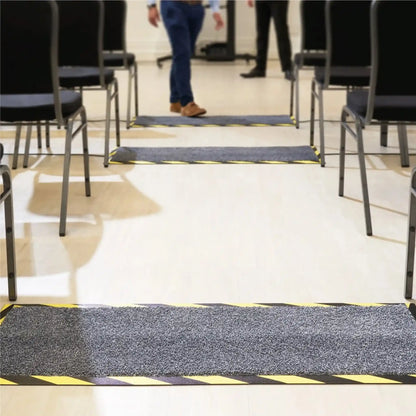 Tapis passe-câbles professionnel installé dans une salle de conférence pour sécuriser les passages de câbles et réduire les risques de trébuchement du public.